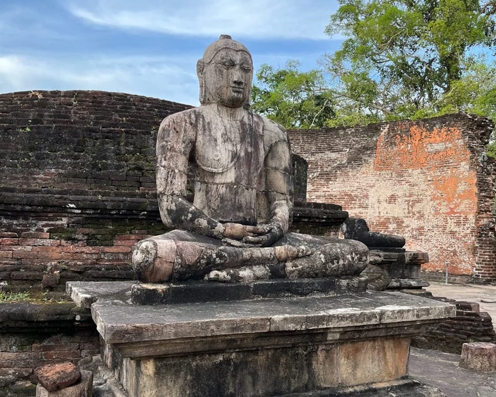Ancient seated Buddha statue among the ruins of Polonnaruwa